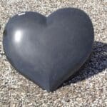 Et billede af en sort gravsten formet som et hjerte